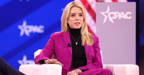 Pam Bondi sitting in a pink blazer