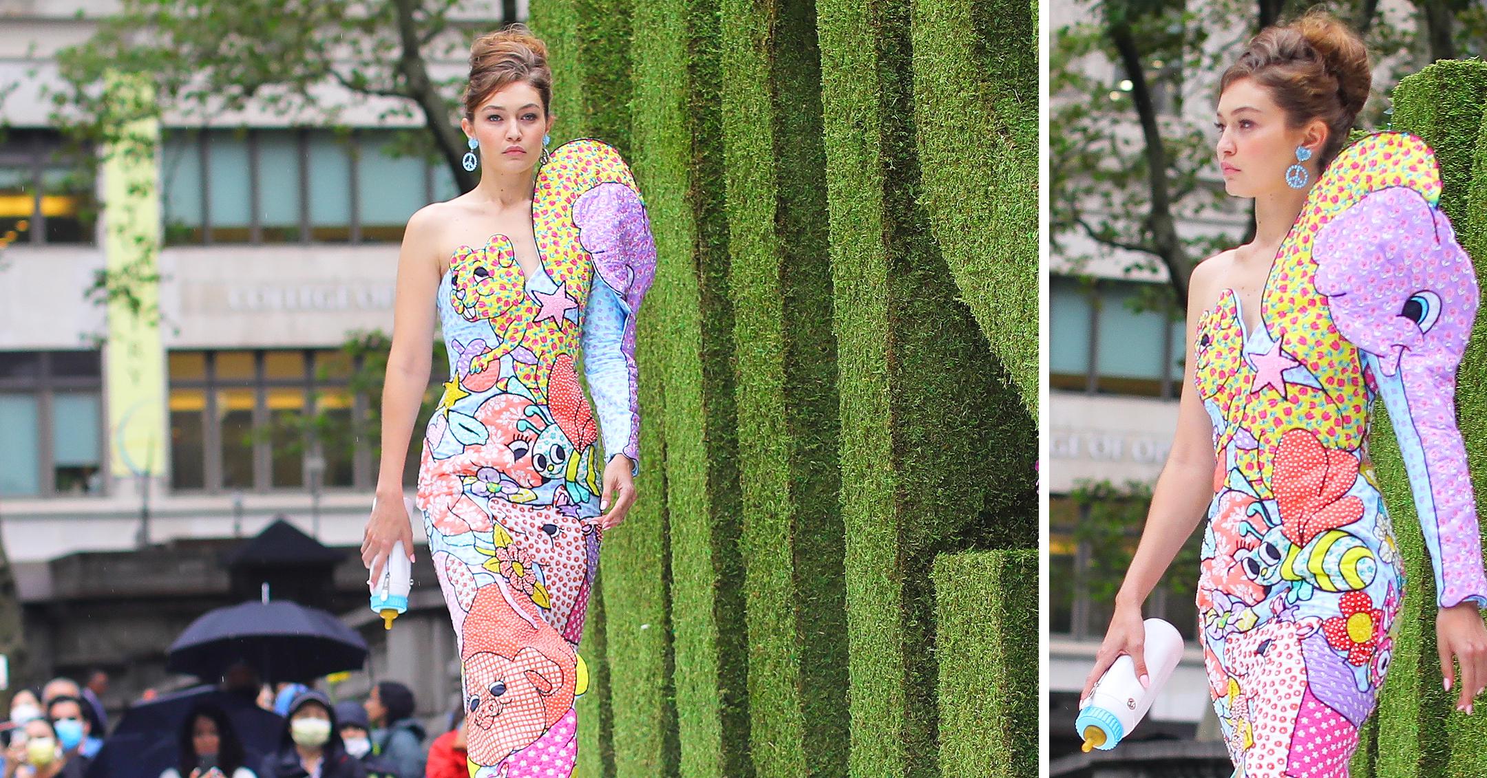 gigi hadid carries a baby bottle and dress made of baby toys as she walks in the moschino fashion show