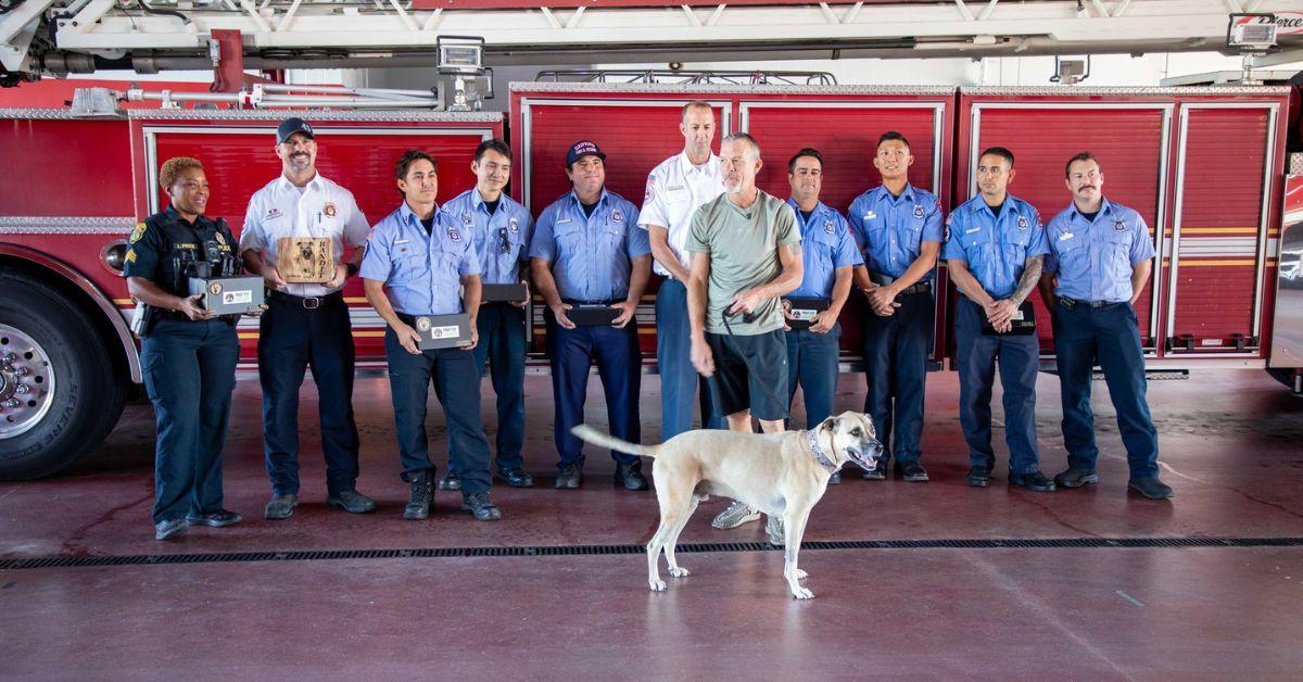 Image of Bandit happily posed with his rescuers in the fire house after making a full recovery.